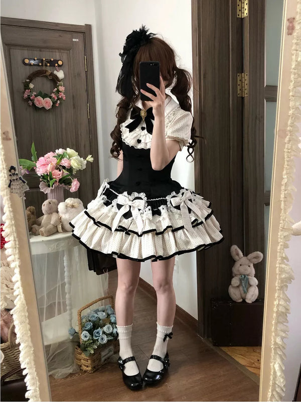 Black-and-white polka-dot Lolita one-piece dress with layered ruffles and ribbon bows.