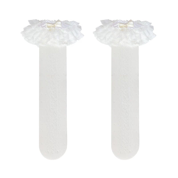 White lace socks with layered ruffles, bow and pearl details worn on the legs.