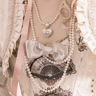 Large pale blue bow brooch pin worn on a pastel Lolita coordinate.