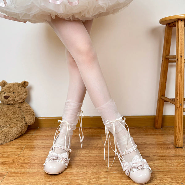 White and black mesh mid-calf socks with double bows styled with platform shoes