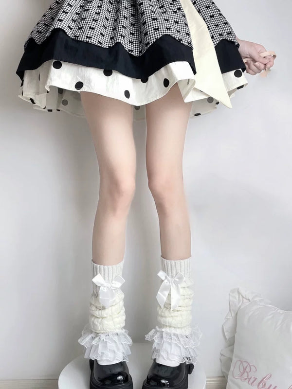 Fantasy Doll white knit leg warmers with lace ruffles and bows worn above black platform shoes.