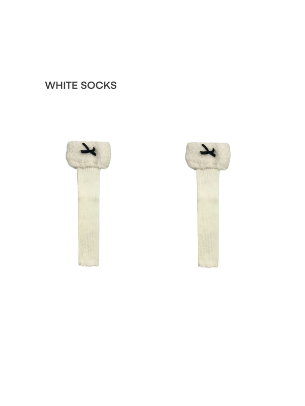 White Socks knit leg warmers with fleece cuffs and bows shown on a white background.