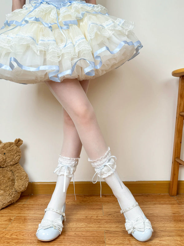 Chubby Bear Tales white socks with blue ribbon ties and lace cuffs, shown in a pastel Lolita coordinate.