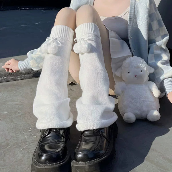 White knitted sock covers with blue pom-pom bows and long slouchy cuffs