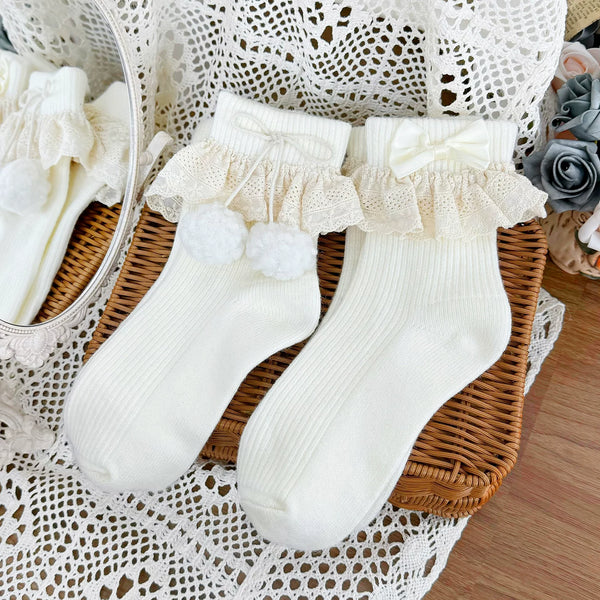 Milky white short socks with lace cuffs and pom-pom details
