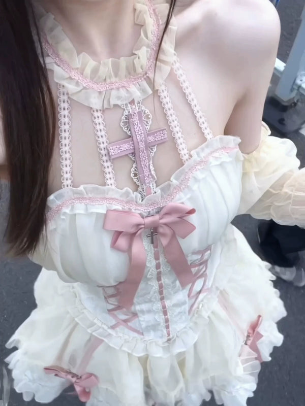 Pink and white Gothic Lolita dress with ruffles, bows and a cross ornament.