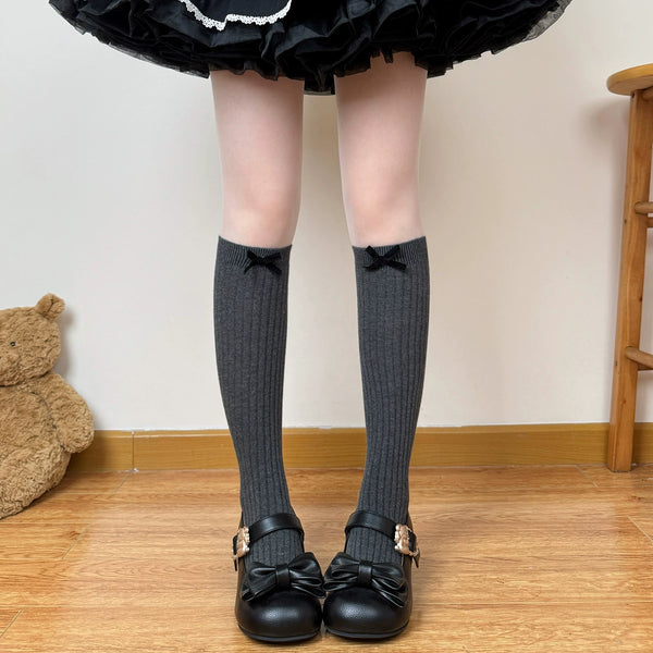 Dark gray and coffee brown ribbed slouch socks with small bows shown in styled coordinates.