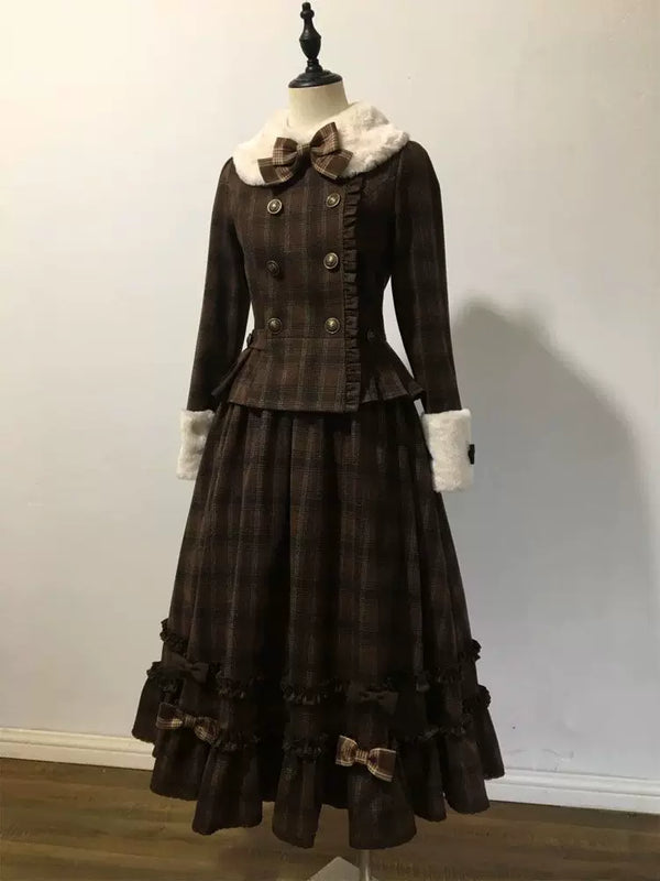 Model wearing a dark plaid two-piece set with a short jacket, long skirt and plush-trimmed collar.