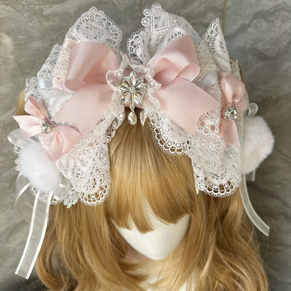 Lace-framed red bow headband with jeweled center, pom-poms and trailing ribbons.