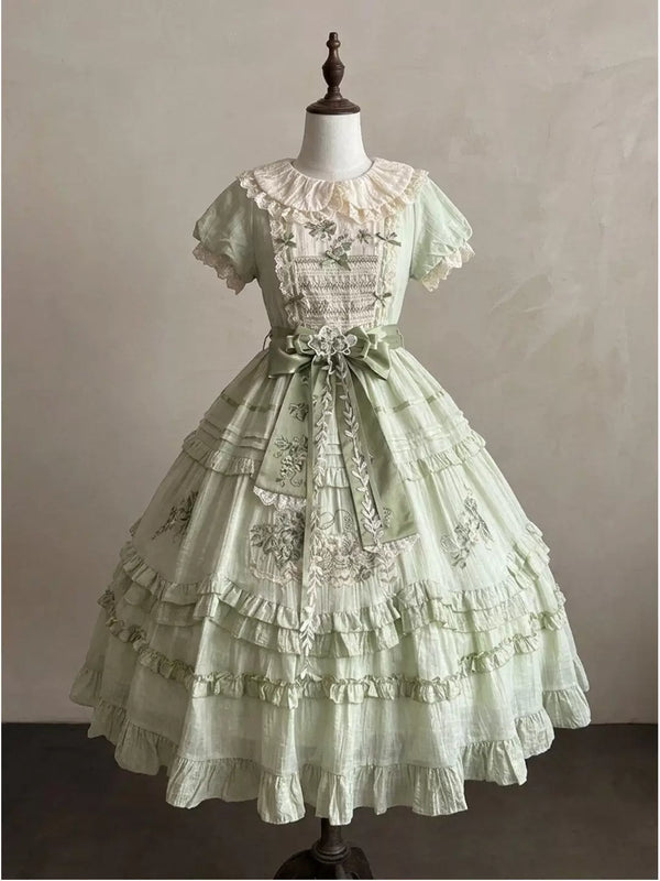 Pale sage green lolita OP dress with cream lace collar, puff sleeves, tiered mid-calf skirt, and sage green satin waist bow
