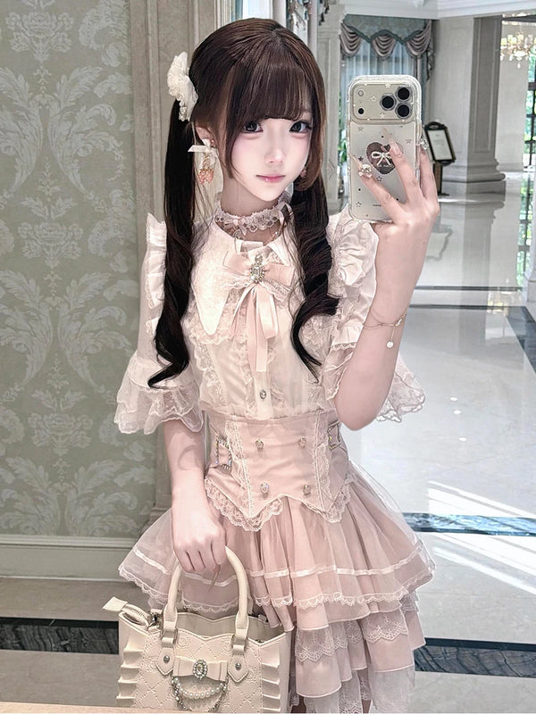 Modelled view of a white-and-pink lace-trimmed top and layered skirt set with bow accents.