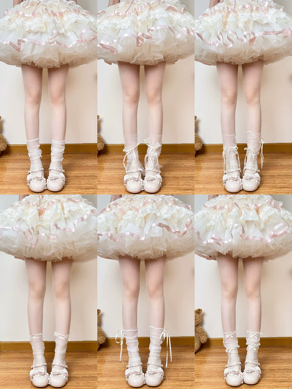 White bow and lace mesh socks styled beneath a pale ruffled skirt.