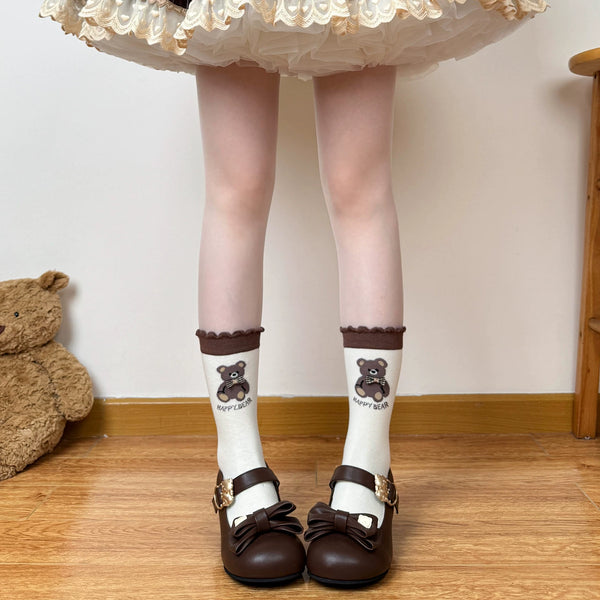 Model wearing brown-and-cream mid-calf socks with bear motifs and stripes.