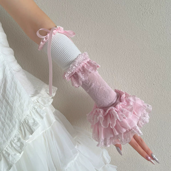 Pink and white ruffled arm sleeves with ribbon ties worn over a white dress.