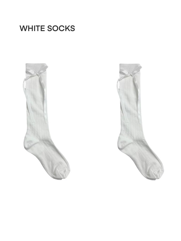 White and grey slouch mid-calf socks with long ribbon bows at the cuffs.