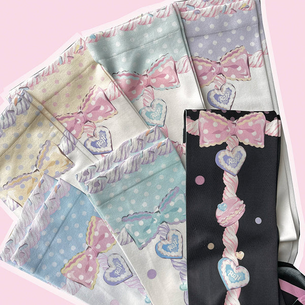 Pastel macaron-print over-the-knee socks with bows, hearts and candy motifs styled with a light Lolita outfit.