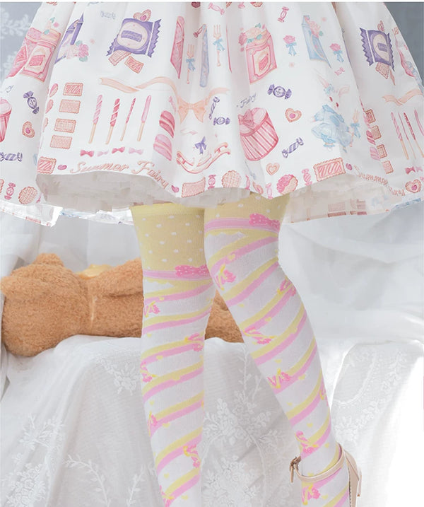 Pastel diagonal-stripe over-the-knee socks worn beneath a printed skirt.