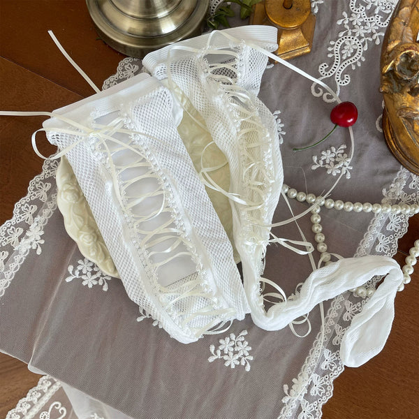 White and apricot layered hosiery with lace-up panel, straps, ribbons, and lace trim