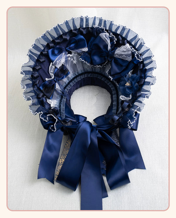 Navy ribbon-and-lace headwear with oversized bows and trailing ties on a white background.