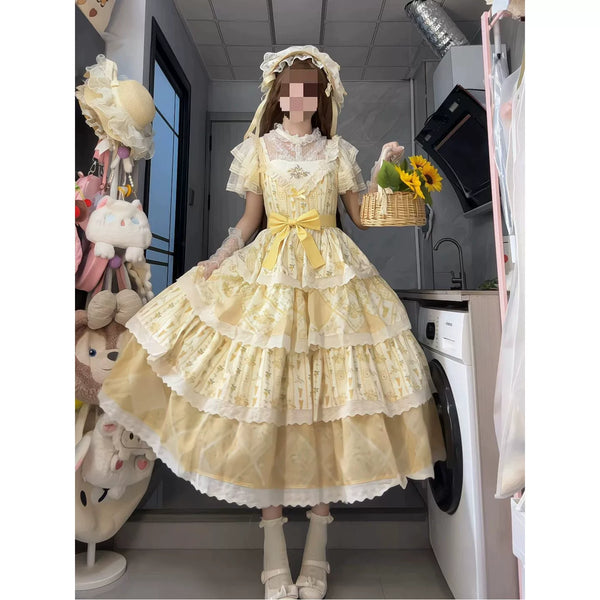 Styled yellow embroidered JSK dress with a waist bow and layered skirt.