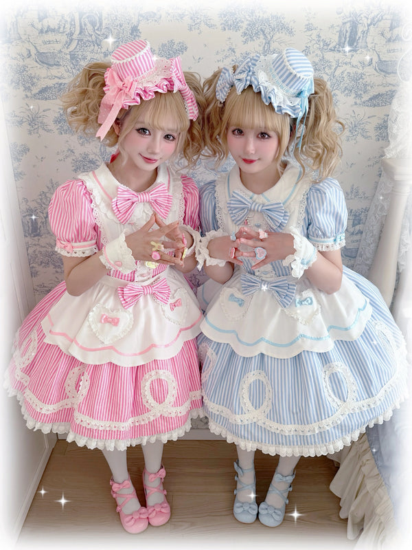 Pink Sweet Lolita OP dress with vertical white stripes, lace trim, and heart appliqués on the apron front