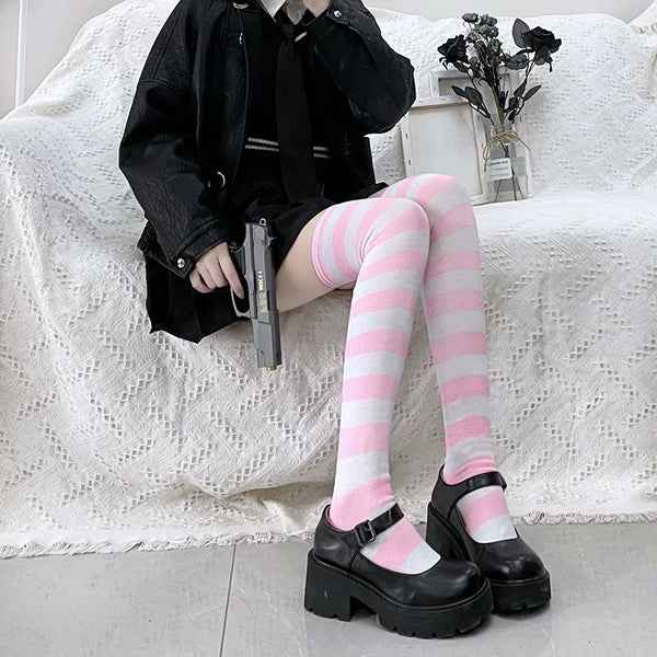 Black-and-white striped over-the-knee socks worn with black platform Mary Jane shoes.