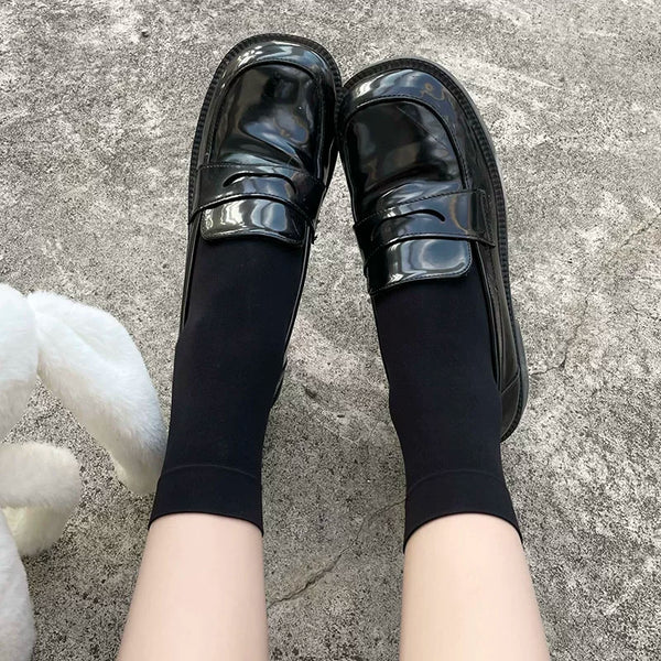 Black velvet-finish mid-calf socks styled with glossy black Mary Jane shoes