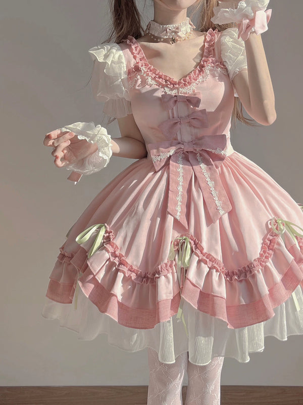 Creamy pink Lolita OP dress with white puff sleeves and layered bows.