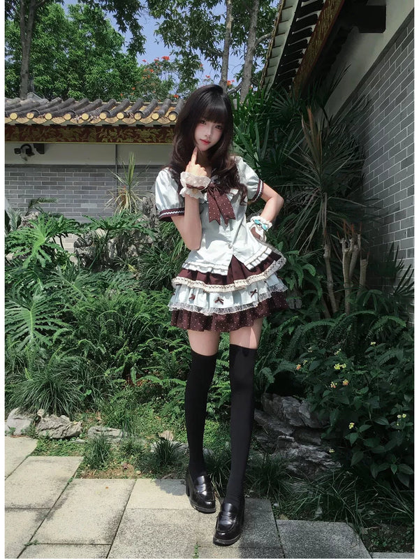 Light blue and brown short-sleeve top and short skirt set with a bow, worn outdoors.