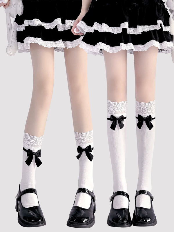 White socks with lace bands and black bows styled with a black skirt and patent shoes