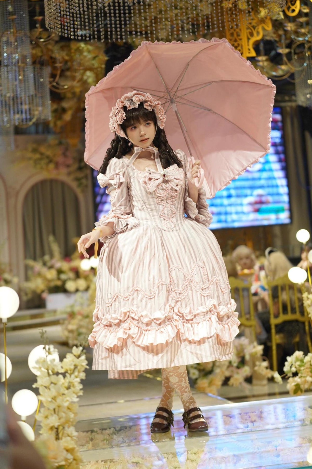 Full-length pink Lolita outfit with a parasol
