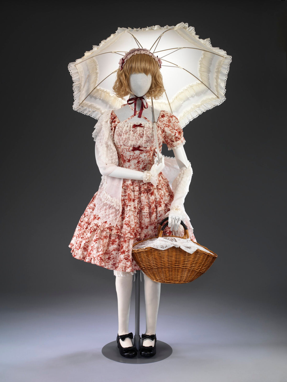 A red and cream Innocent World Lolita ensemble with parasol and basket