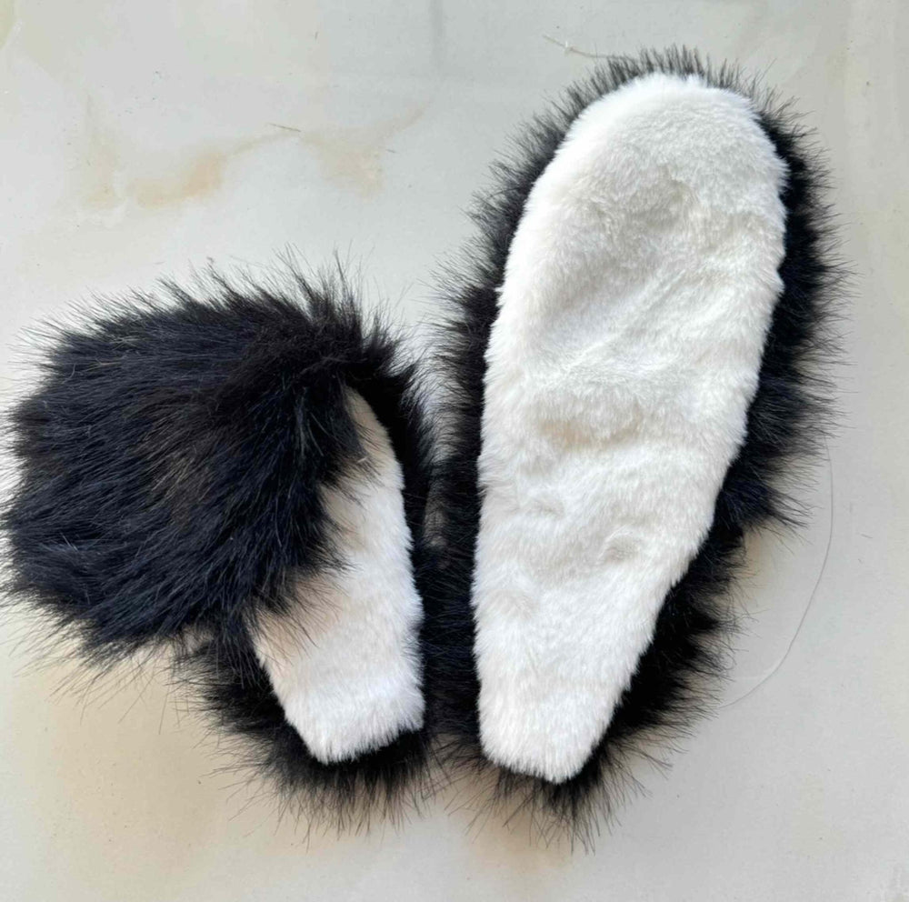 Black-and-white furry bunny-ear headdress shown on a flat surface.