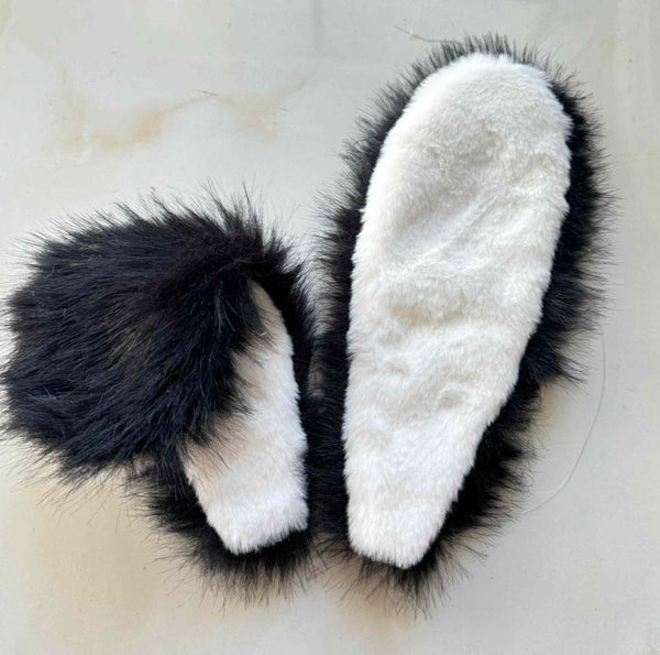 Black-and-white furry bunny-ear headdress shown on a flat surface.
