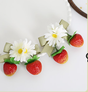 ein Paar Haarklemmen mit Erdbeeren im Farbverlauf und Schleifen