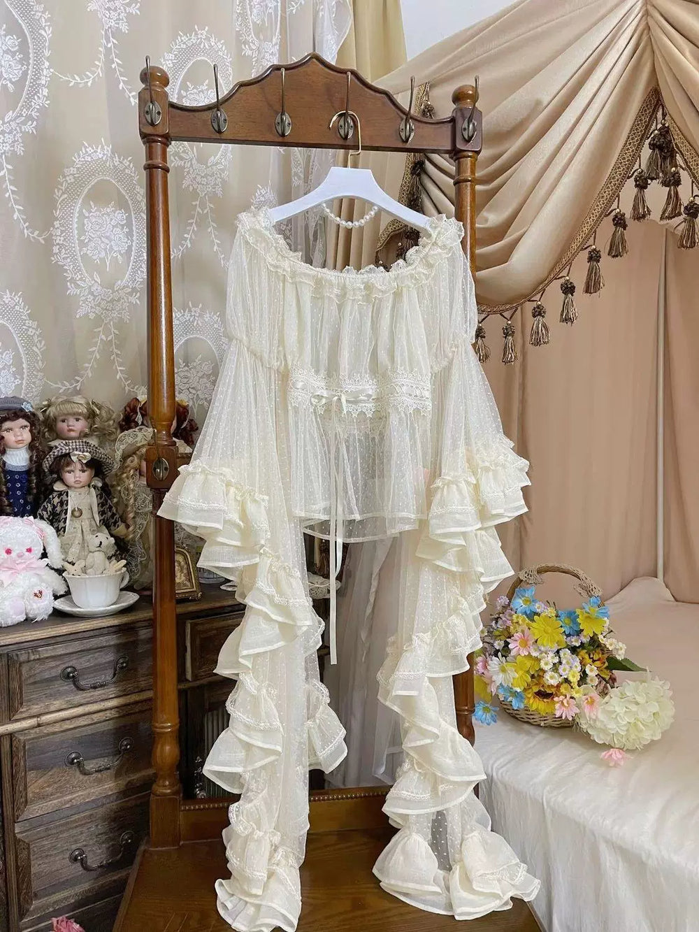 White off-shoulder Lolita Blouse with sheer dotted mesh sleeves and layered ruffled trim on a wooden hanger.