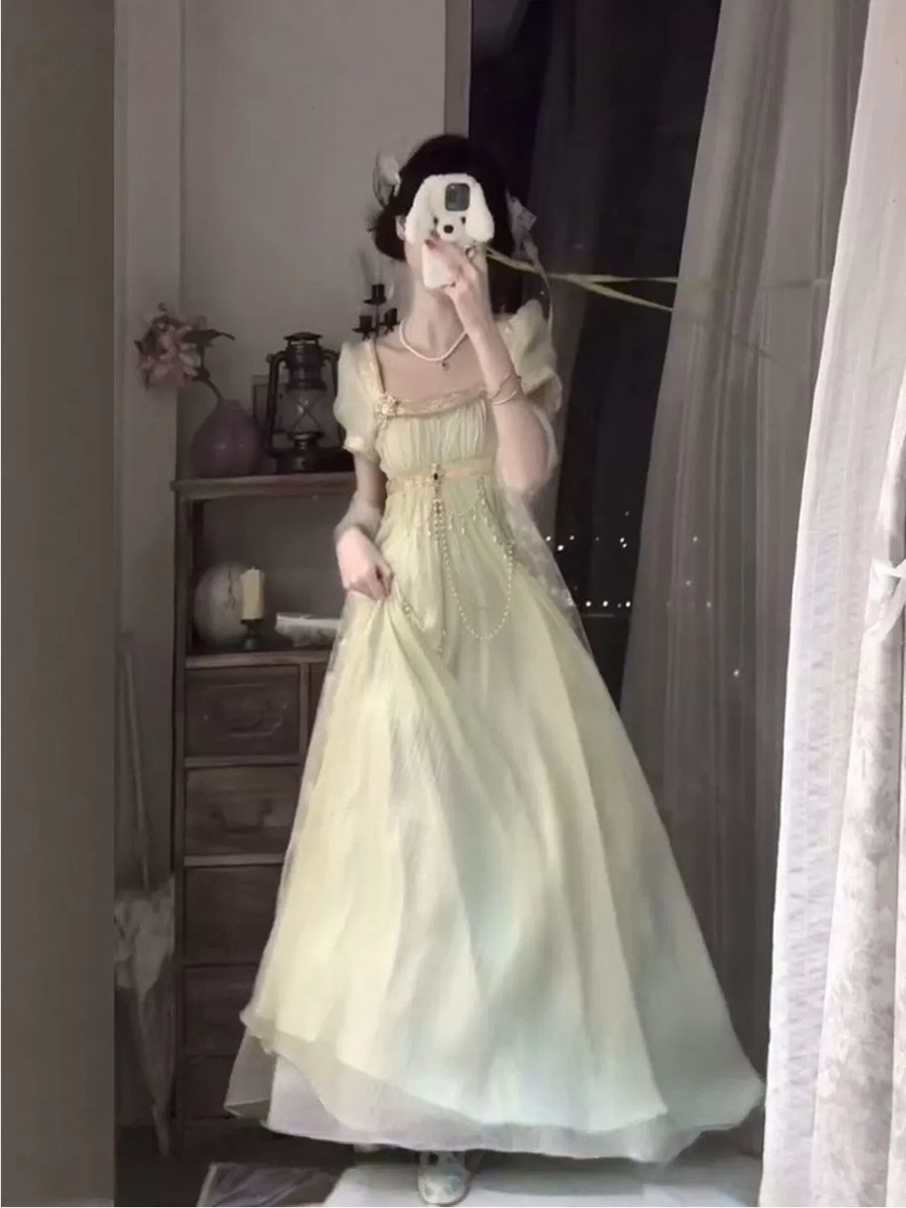 Pale green empire-style OP dress with puff sleeves and waist chain in a mirror selfie.
