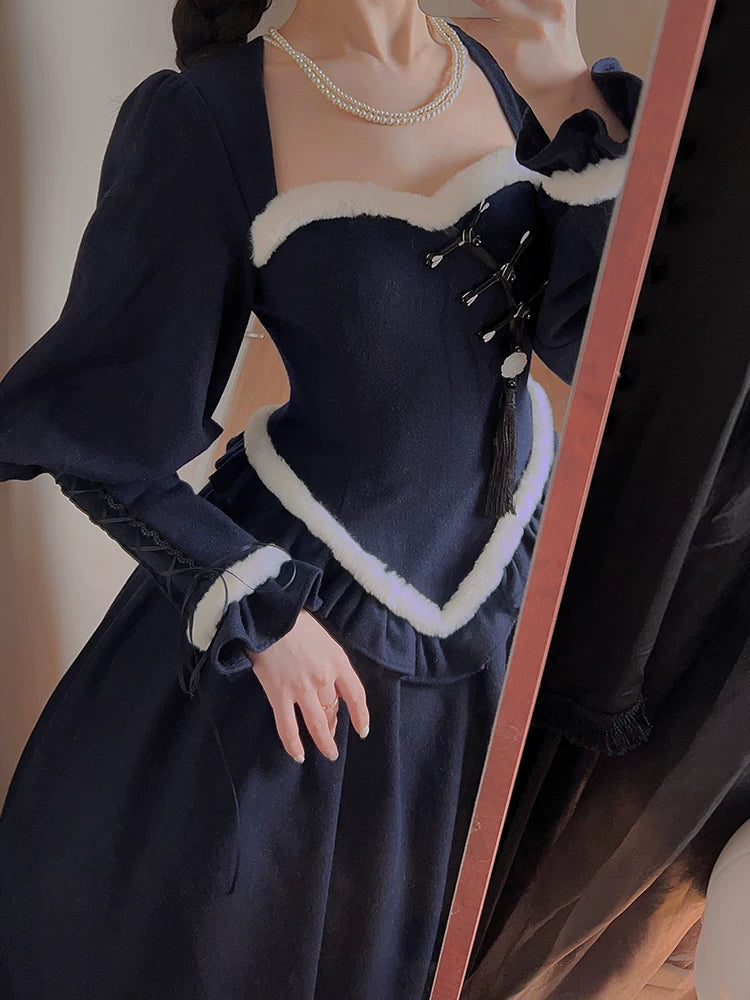 Model wearing a navy long-sleeved OP with white trim, cape and pearl necklace.