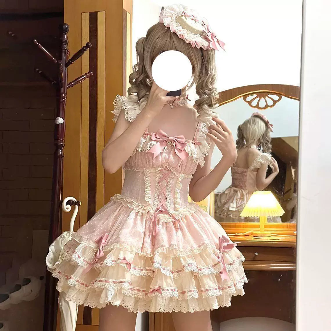 Pink and ivory ruffled camisole dress shown on a model in close-up and outdoors.