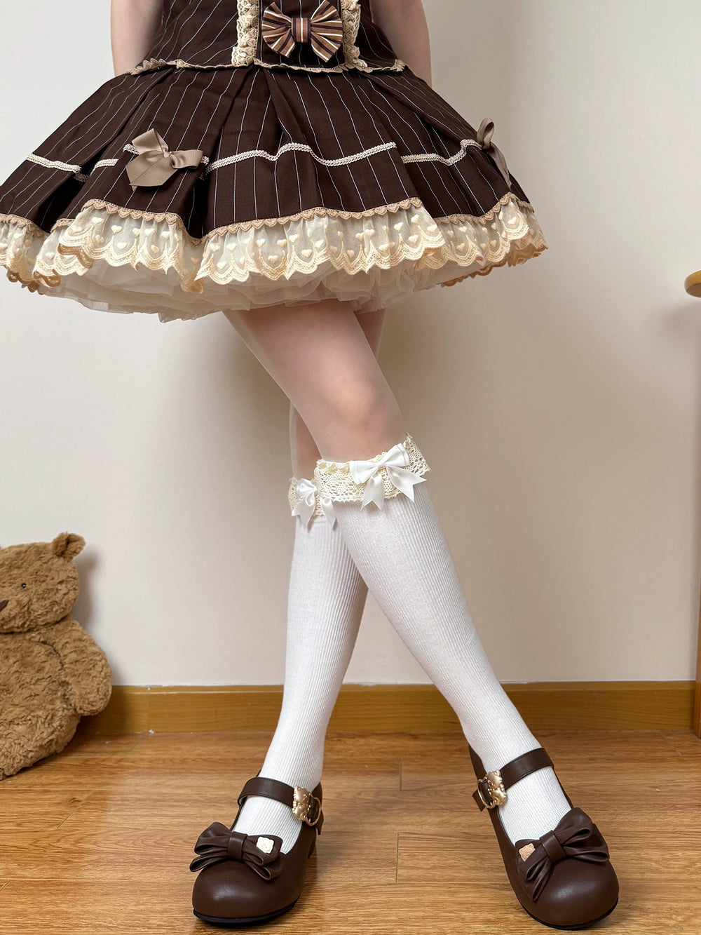 Brown and white lace-cuff socks styled with bow details beneath a Lolita skirt.