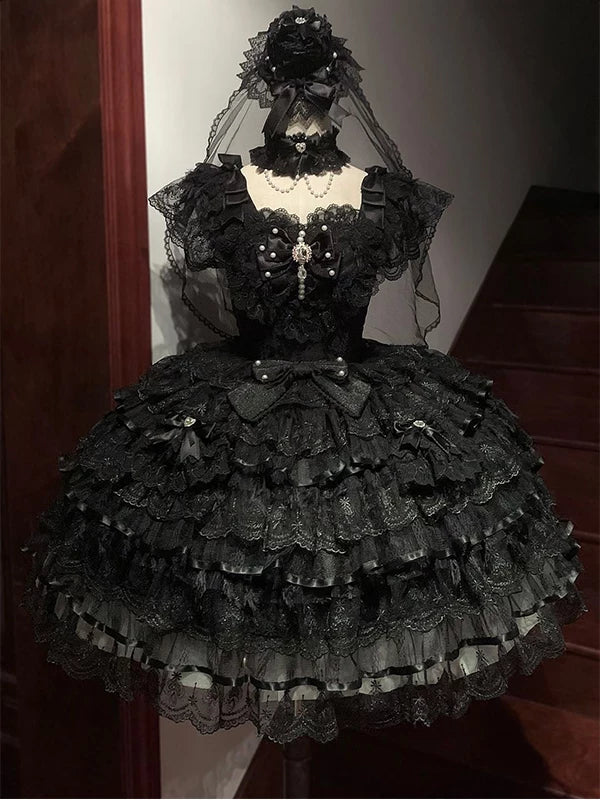 Black tiered-lace JSK with bow detailing and matching accessories displayed on a mannequin.