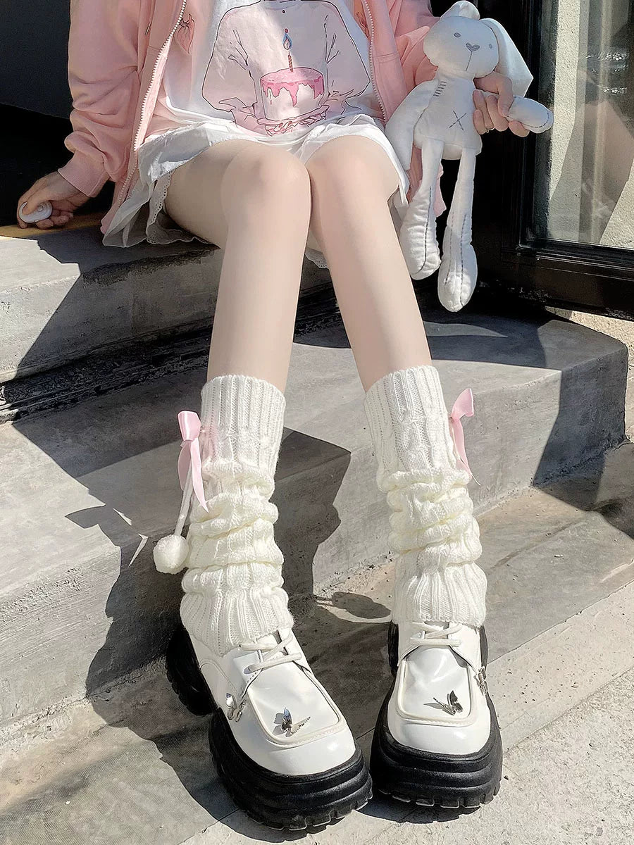 Floral Milk Cat milk-white scrunched leg warmers with ribbon bows and pom-pom accents