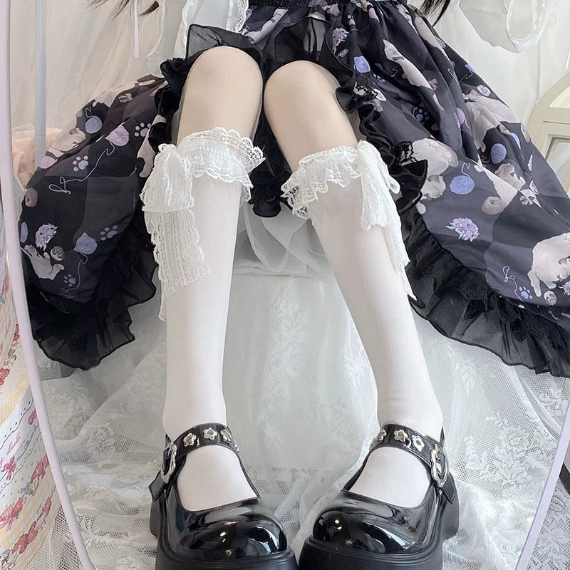 Model wearing white lace-cuff calf socks with a dark floral Lolita dress