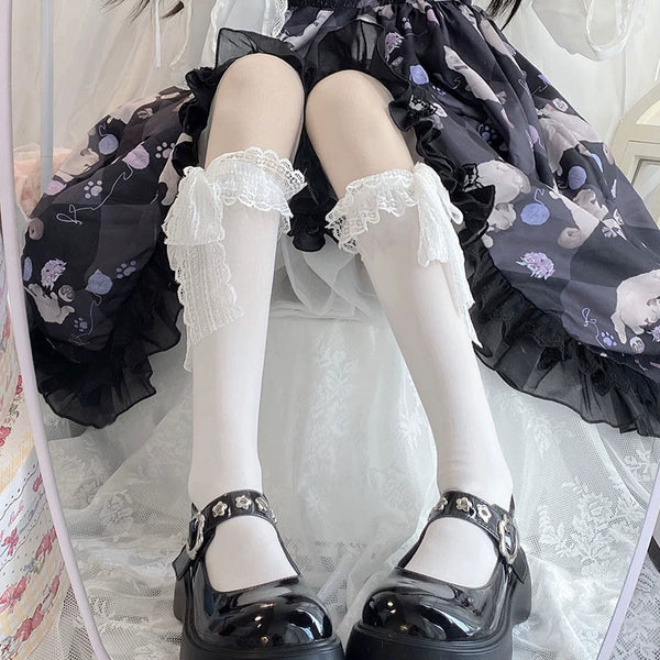 Model wearing white lace-cuff calf socks with a dark floral Lolita dress