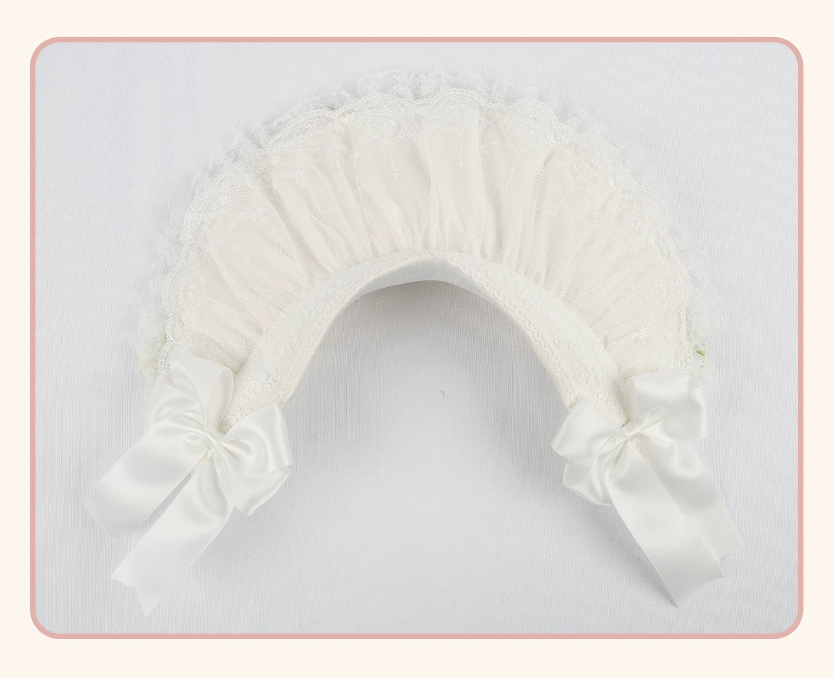 White lace-trimmed flat hat with a pleated crown and long side bows, shown flat.