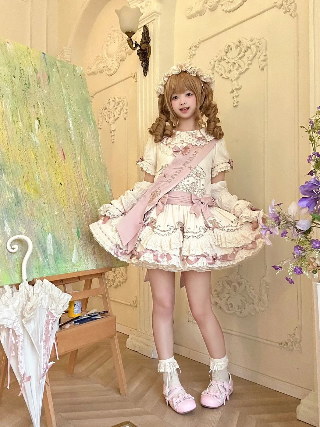 Cream and pink doll-style OP dress with lace tiers and bows shown on a model