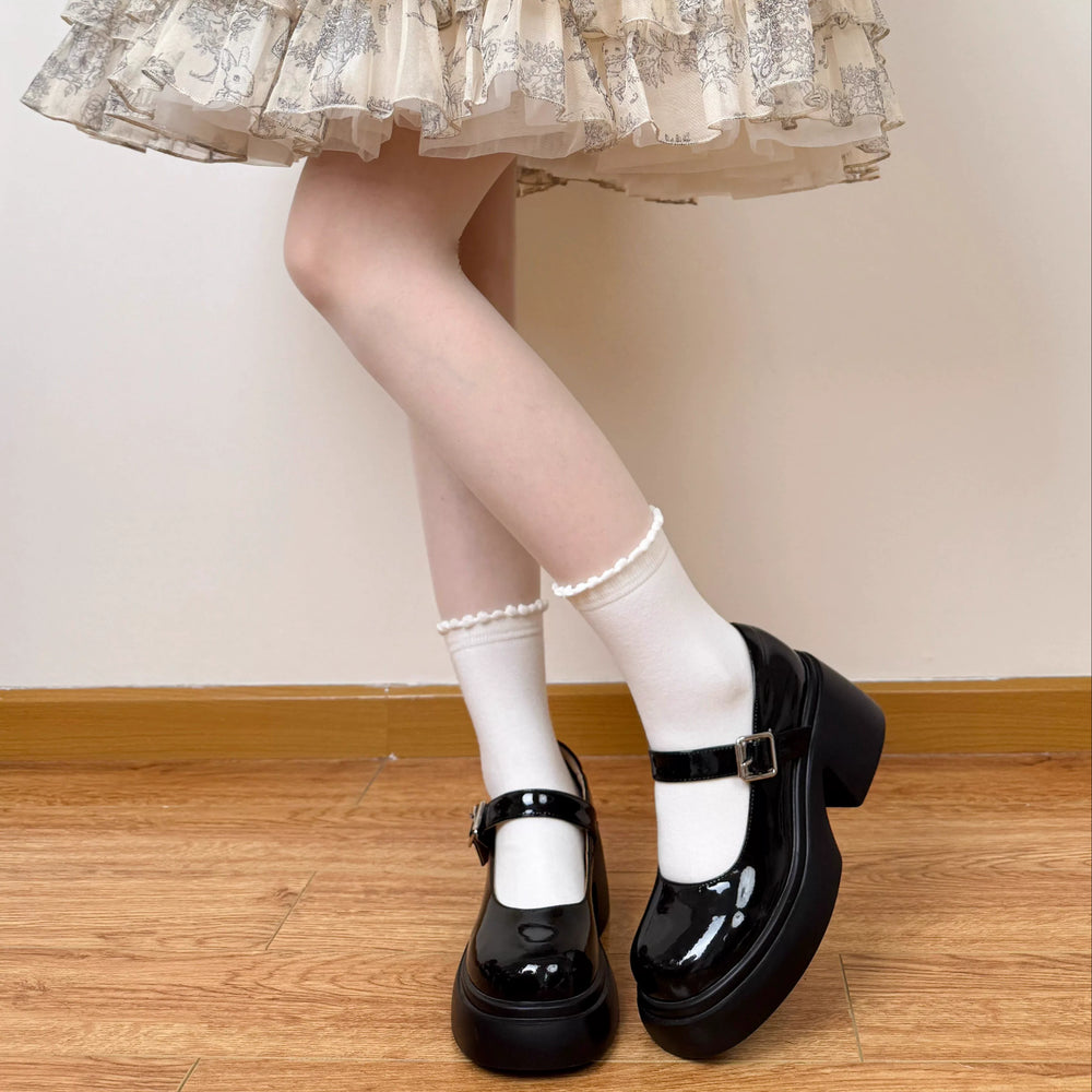 White and black short slouch socks with scalloped lace trim styled with platform shoes