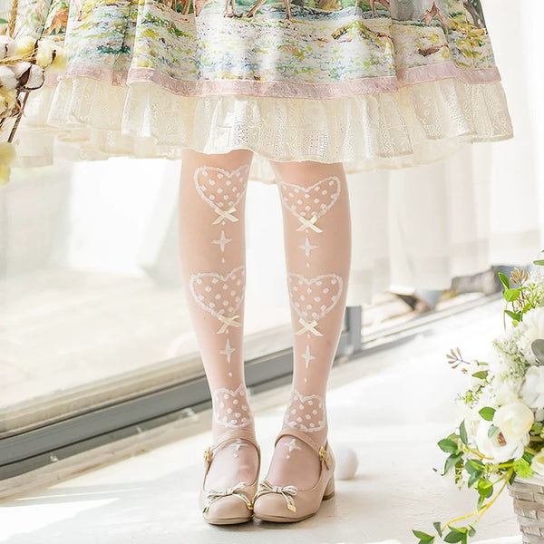 White heart-motif over-the-knee socks with red bows styled with a white dress and Mary Jane shoes.