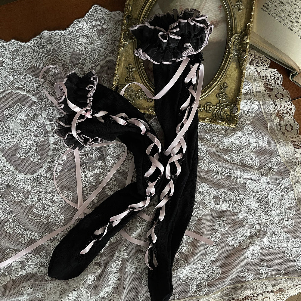 Pink-and-black striped and black lace legwear styled with ruffles, tie straps, a leg ring and platform shoes.