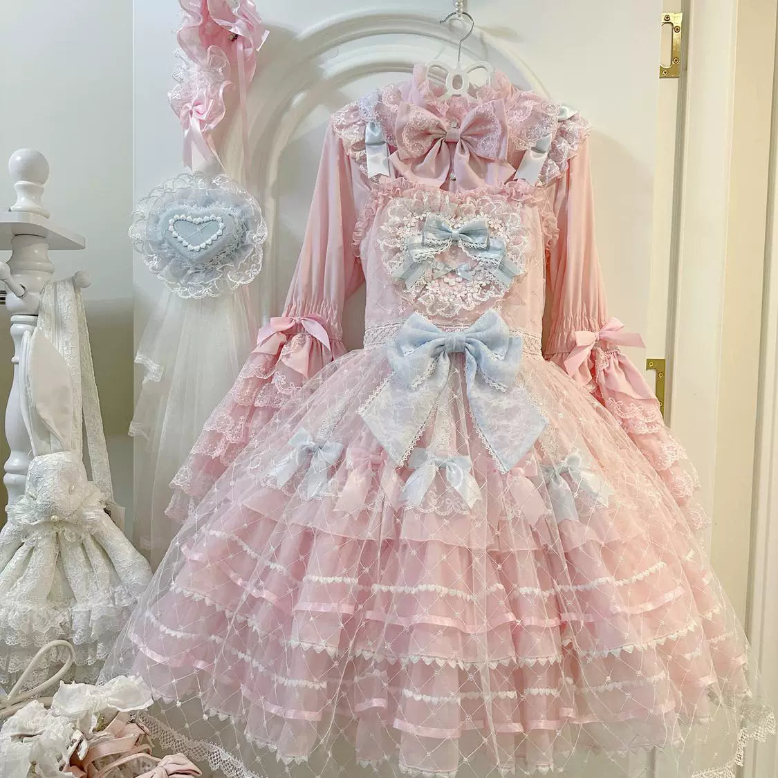 Lady Han Camellia Cherry Overture sweet JSK dress from Lolita Fetch featuring a floral cherry blossom pattern on a pink fabric.